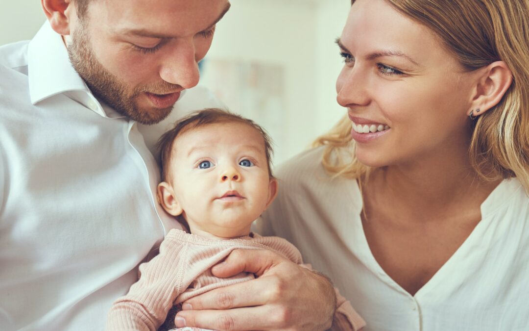 Proud mother and father with their baby girl at home