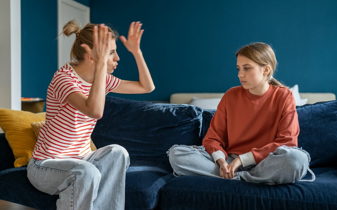 Young angry emotional mother screaming at troubled teen daughter at home